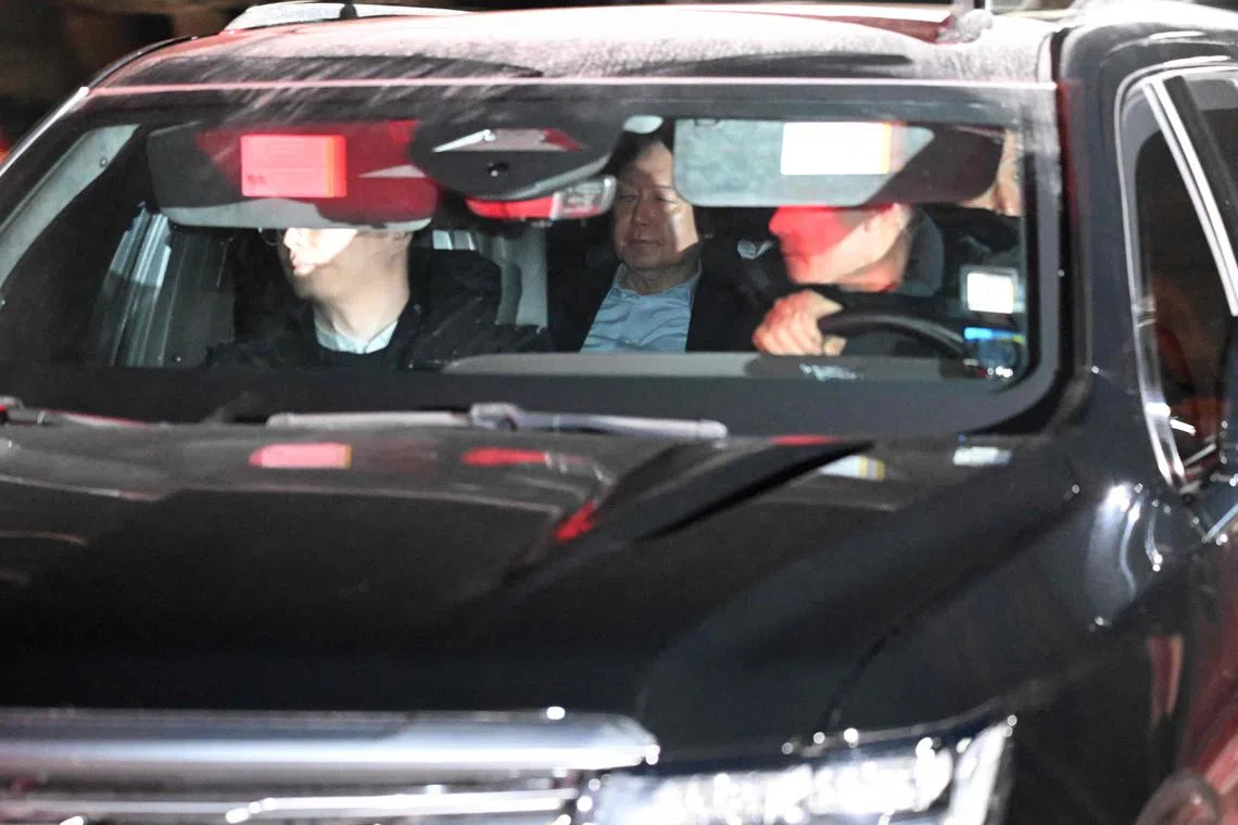 A vehicle carrying impeached South Korea President Yoon Suk Yeol (C) leaves the complex building housing the Corruption Investigation Office for High-ranking Officials (CIO) in Gwacheon on January 15, 2025. Impeached South Korean leader Yoon Suk Yeol was arrested on January 15 over his failed martial law bid, ending a weeks-long standoff with authorities and becoming the first sitting president to be detained in the nation's history. (Photo by JUNG YEON-JE / AFP)