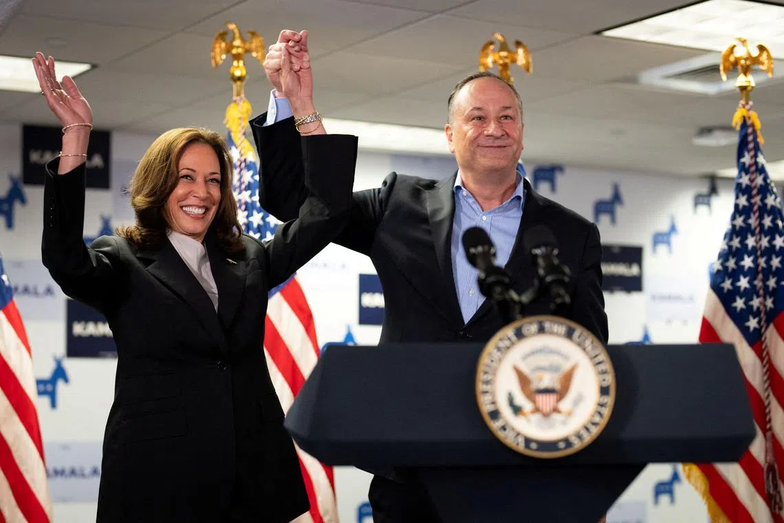 FILE PHOTO: U.S. Vice President Kamala Harris and second gentleman Douglas Emhoff gesture at Kamala's Presidential Campaign headquarters in Wilmington, DE, U.S.,  July 22, 2024.  Erin Schaff/Pool via REUTERS/File Photo