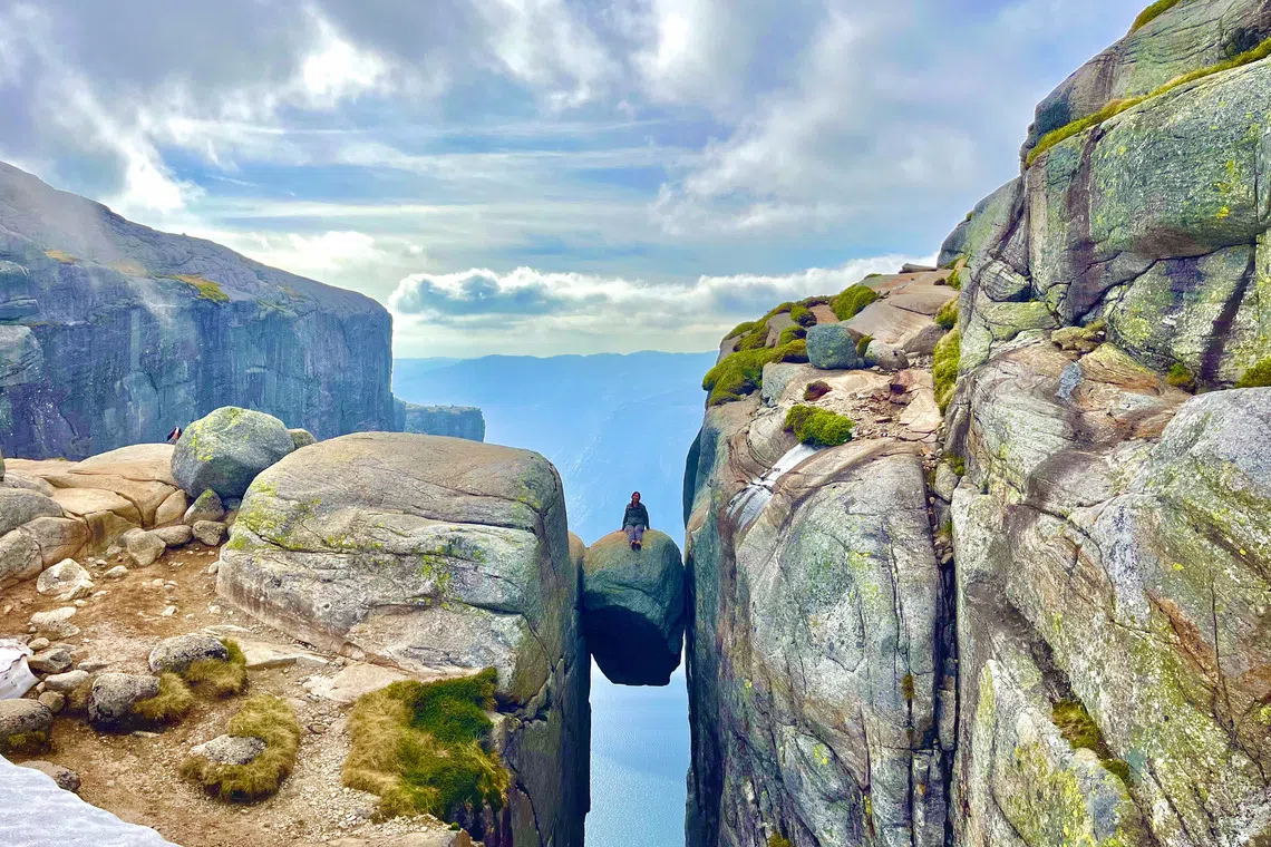 Ms Fiona Lee on a boulder wedged in a crevice in the Kjerag mountain in southern Norway in June 2024. 