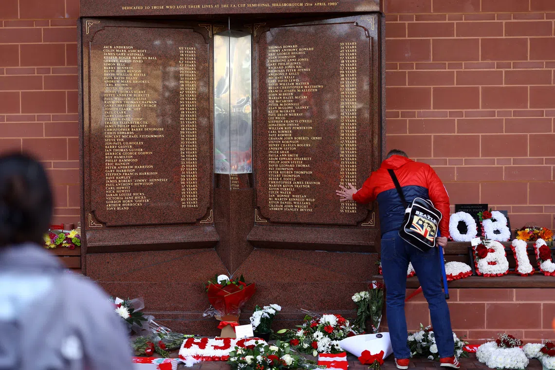 Soccer Football - Premier League - Liverpool v Crystal Palace - Anfield, Liverpool, Britain - April 14, 2024 Fans look at a Liverpool memorial in memory of the victims of the Hillsborough disaster outside the stadium before the match REUTERS/Carl Recine