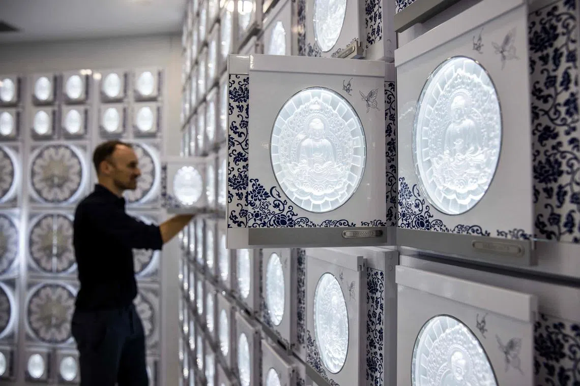 This picture taken in Hong Kong on June 7, 2023 shows a niche (R) that holds funeral urns at the Shan Sum columbarium. With its white marble foyer and lavish chandeliers, the 12-storey tower could be mistaken for one of Hong Kong’s newest hotels, but it offers a longer stay: a resting place for thousands in one of the world's most crowded cities. (Photo by ISAAC LAWRENCE / AFP) / TO WITH AFP STORY:  Hong Kong-China-funeral-parlour-death, FOCUS