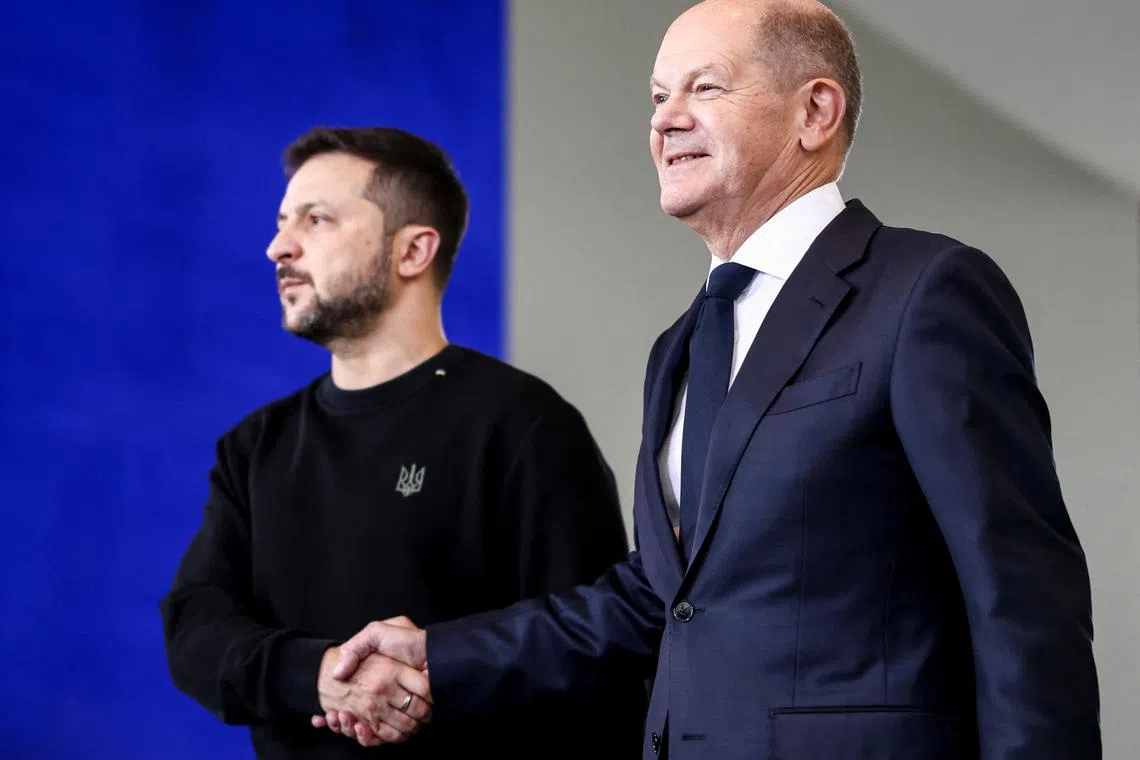FILE PHOTO: Ukrainian President Volodymyr Zelenskiy shakes hands with German Chancellor Olaf Scholz in Berlin, Germany, October 11, 2024. REUTERS/Liesa Johannssen/File Photo