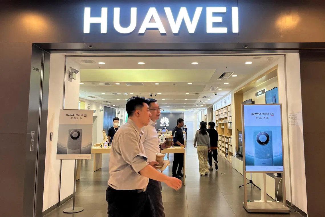 FILE PHOTO: People walk past a Huawei store with advertisements for the Mate 60 series smartphones, at a shopping mall in Beijing, China August 30, 2023. REUTERS/Yelin Mo/File Photo