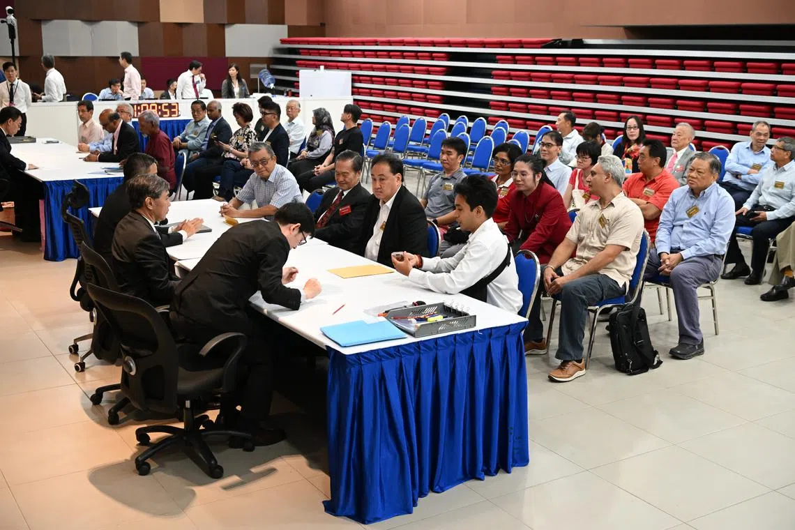 Tan Kin Lian submitting his nomination papers to the returning officer in the nomination hall.