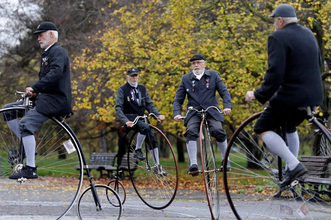 Participants wearing historical costumes ride their high-wheel bicycles during the annual penny farthing race in Prague, Czech Republic, Nov 5, 2022. 