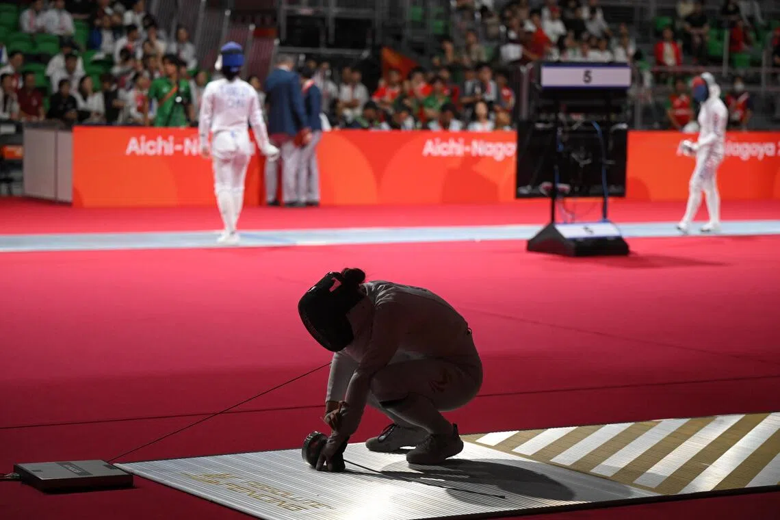 A dejected Elle Koh of Singapore take a minute after losing against Tamaki Terayama during the Women's Epee Individual quarterfinals at the Aichi Sky Expo Hall on Sept 22, 2026.