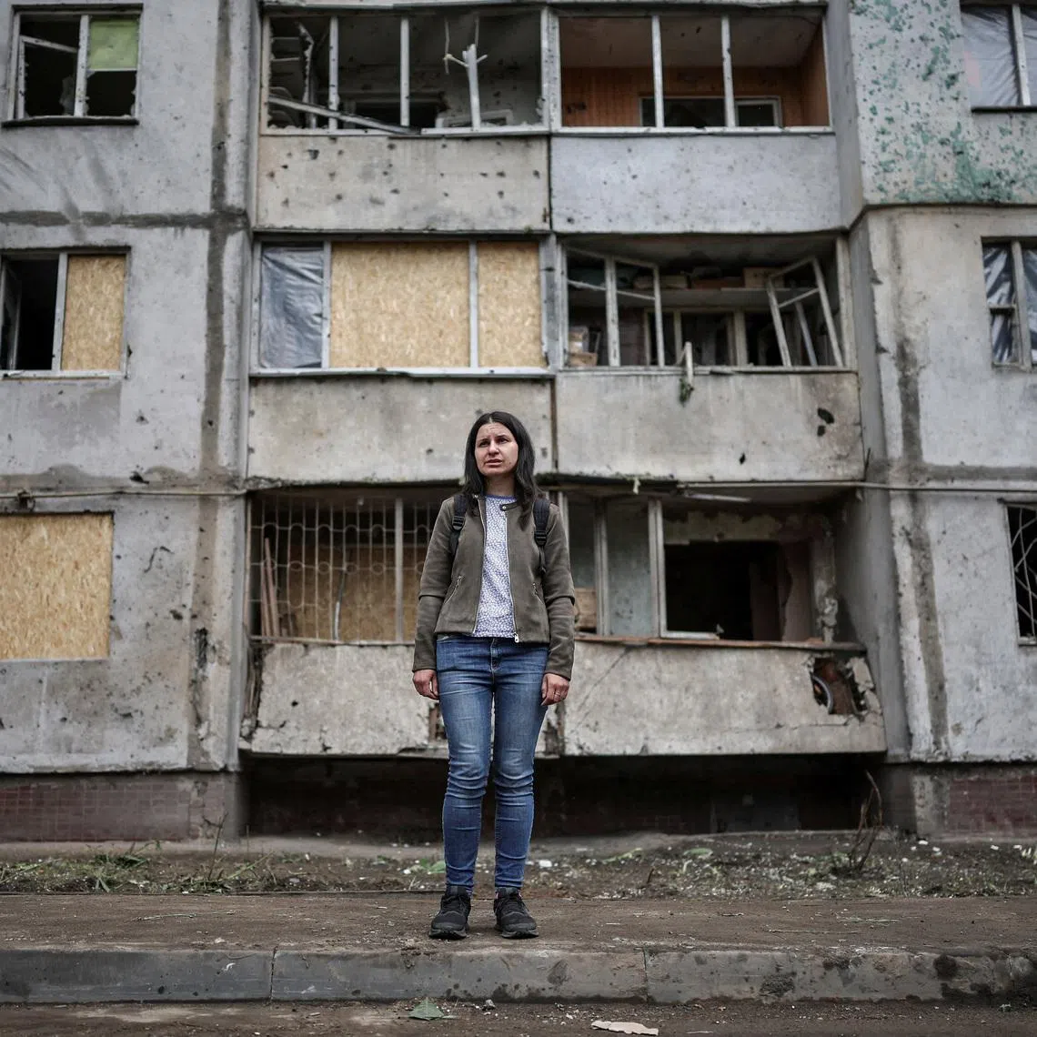 Olha Mudra, 35, a resident who survived yesterday's Russian missile and drone attack, poses for a photo in front of the residential building she lives in, which was damaged during the strike, amid Russia's attack on Ukraine, in Kyiv, Ukraine July 3, 2026. REUTERS/Alina Smutko