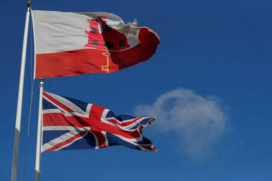 FILE PHOTO: The Gibraltarian and Britain's Union Jack flags fly at the border between Spain and Gibraltar, January 1, 2021. REUTERS/Jon Nazca/File Photo
