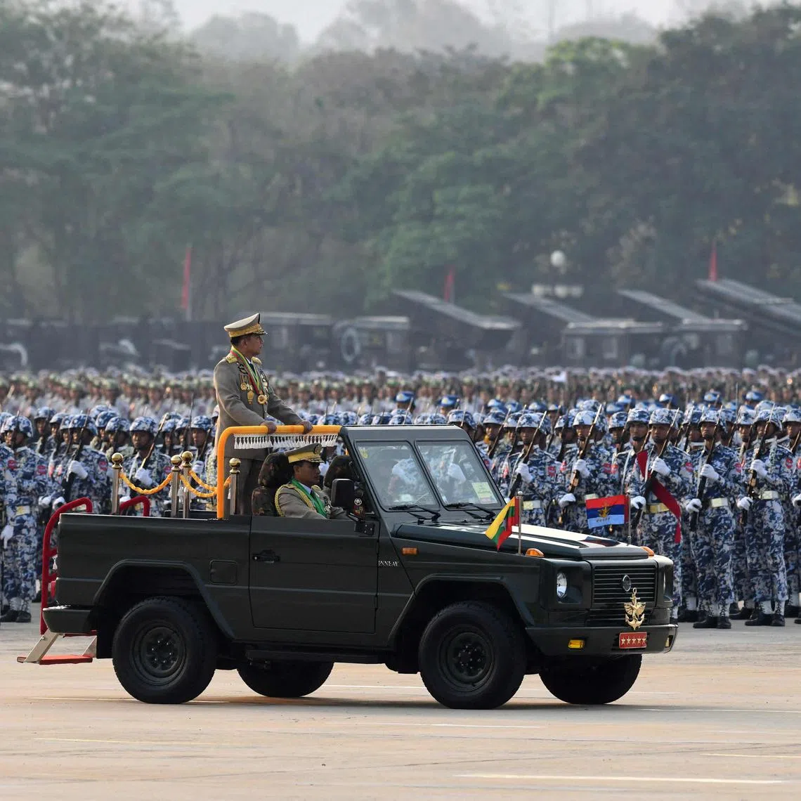 Myanmar's Chief Senior General Min Aung Hlaing stands in a vehicle as he attends a ceremony to mark the country's 78th Armed Forces Day in Naypyidaw on March 27, 2023. (Photo by AFP)