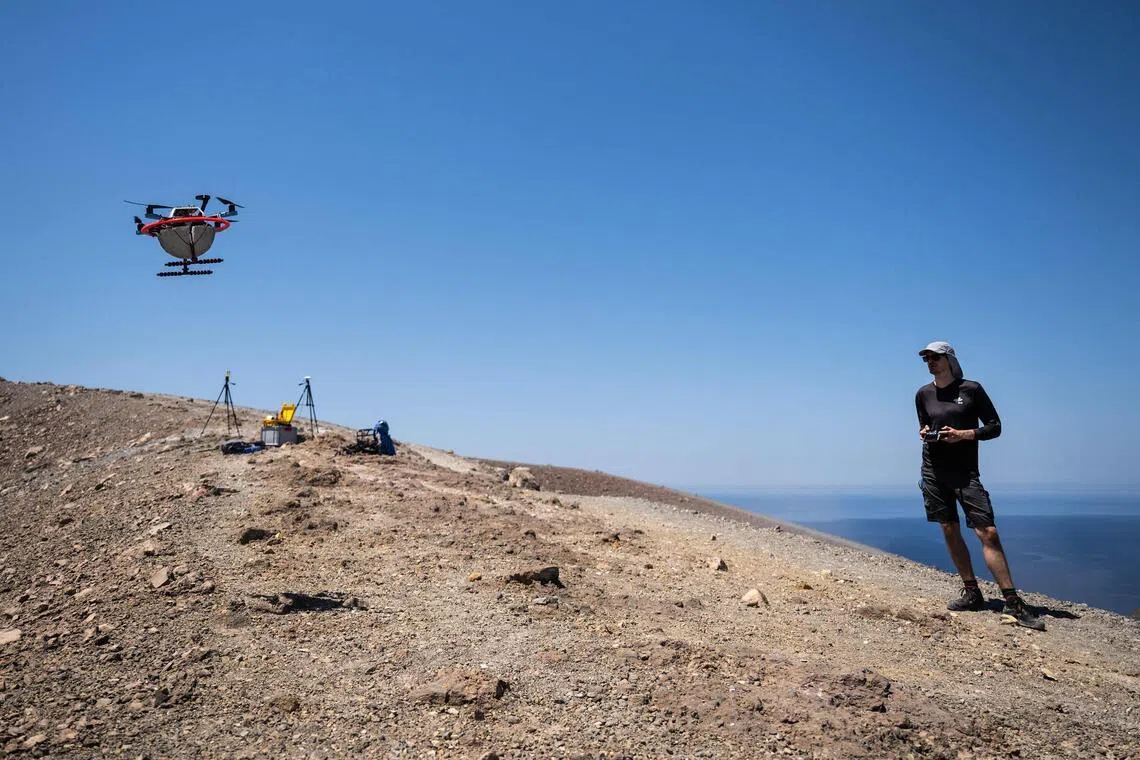 A vulcanologist from the University of Munich pilots a drone with a mirror used to reflect a laser and collect data from gas emissions in the crater of La Fossa, on Vulcano Island.
