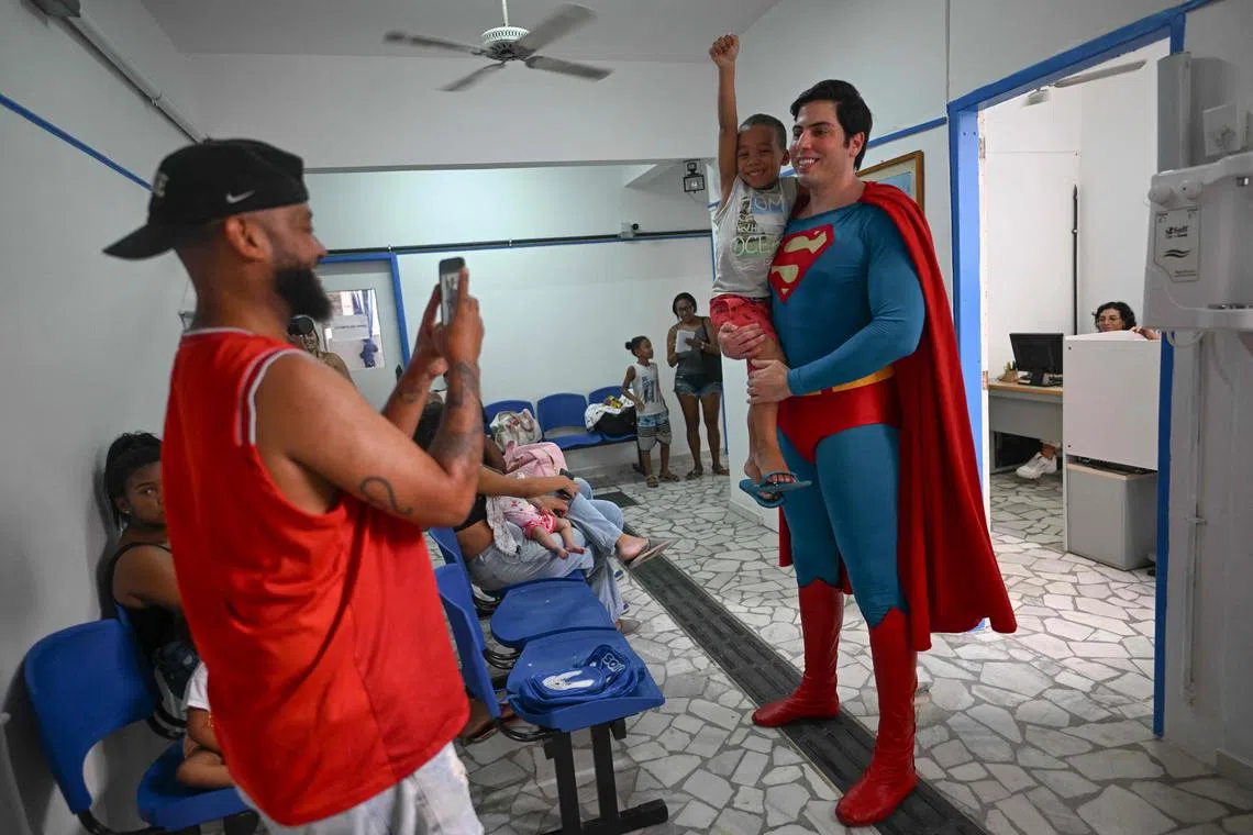 Leonardo Muylaert, 36, known as the Brazilian Superman, poses with a boy at the Association of Parents and Friends of Neurodivergent People (APAE-RIO) in the Tijuca neighborhood in Rio de Janeiro, Brazil, on March 18, 2024. Muylaert, a lawyer who didn’t have social media one year ago, found out a video of him visiting an event went viral on TikTok, calling him the "Brazilian Superman." He liked the idea and jumped on a Superman costume, and since then, he has been traveling around Brazil as Superman. (Photo by Mauro PIMENTEL / AFP)