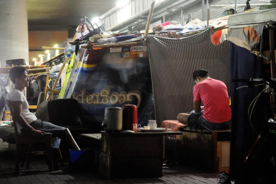 Homeless people living in tents built by poles and sheets under a bridge in Sham Shui Po, Kowloon. 