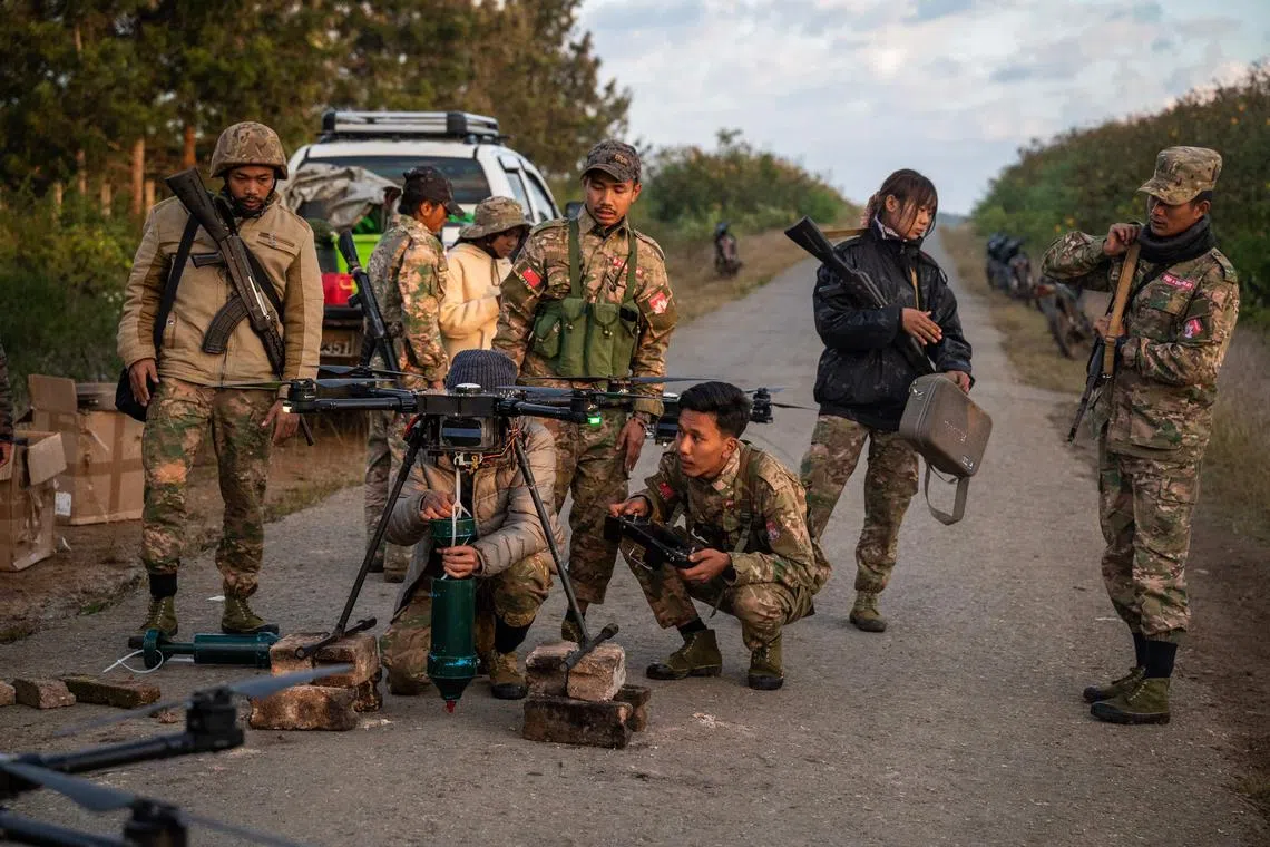 This photo taken on December 11, 2023 shows members of the Mandalay People’s Defense Forces (MDY-PDF) preparing to release a drone near the frontline amid clashes with Myanmar's military in northern Shan State. A squad of Myanmar pro-democracy fighters works quickly to ready drones for an attack on a nearby military base, the latest target in a wave of aerial assaults that has helped turn the war against the junta. (Photo by AFP) / TO GO WITH Myanmar-coup, FOCUS
