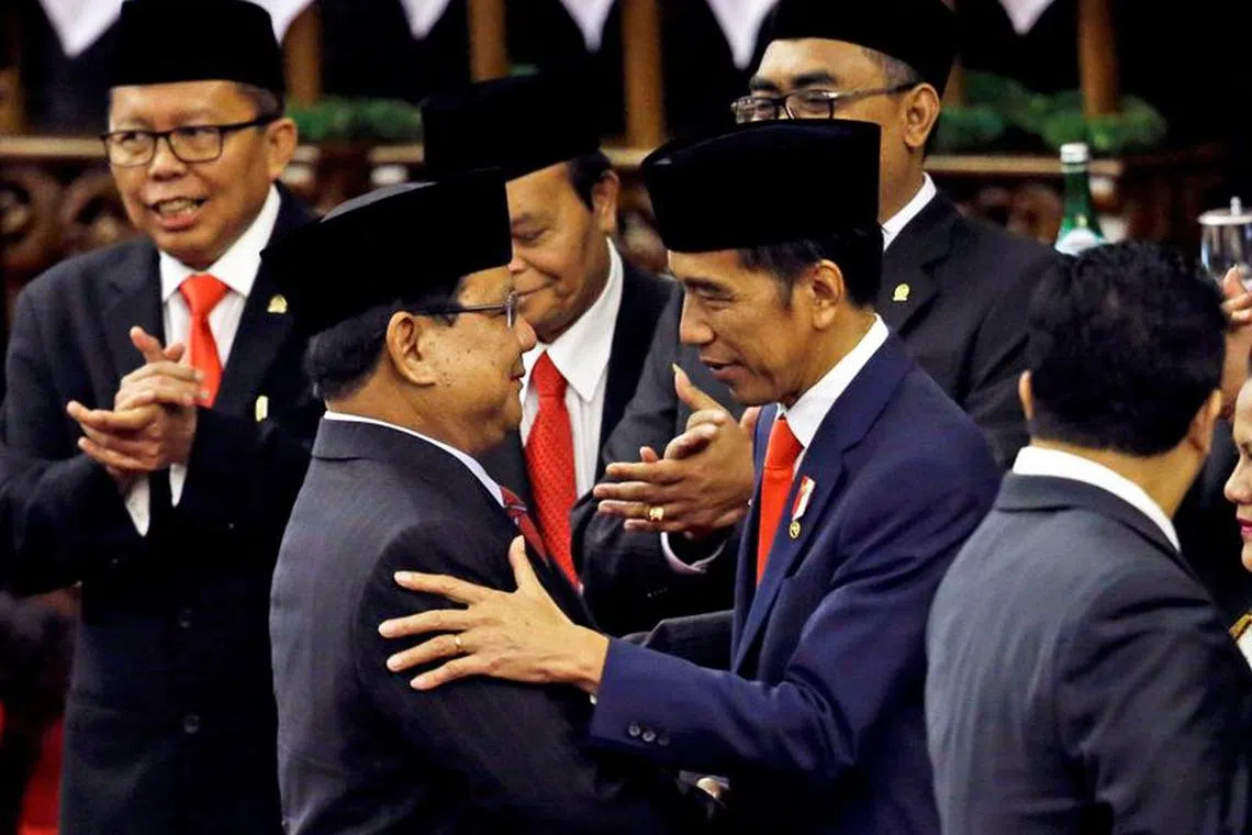 FILE PHOTO: Indonesian President Joko Widodo is congratulated by the Gerindra Party Chairman Prabowo  Subianto, who was his election rival, after his presidential inauguration for the second term, at the House of Representatives building in Jakarta, Indonesia, October 20, 2019. Achmad Ibrahim/Pool via REUTERS/File Photo