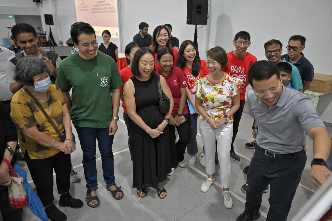 Minister for National Development Desmond Lee (pointing) and Ms Foo Mee Har (in white) viewing plans for Teban and Pandan Gardens alongside residents such as Mr Reginal Satha (in green) and Ms Elsie Nee (in black).