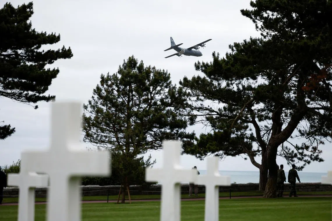 A U.S. Air Force Lockheed Martin C-130 flies over headstones at the World War II Normandy American Cemetery and Memorial situated above Omaha Beach ahead of the 80th anniversary of the 1944 D-Day landings in Colleville-sur-Mer, Normandy region, France, June 2, 2024. REUTERS/Benoit Tessier