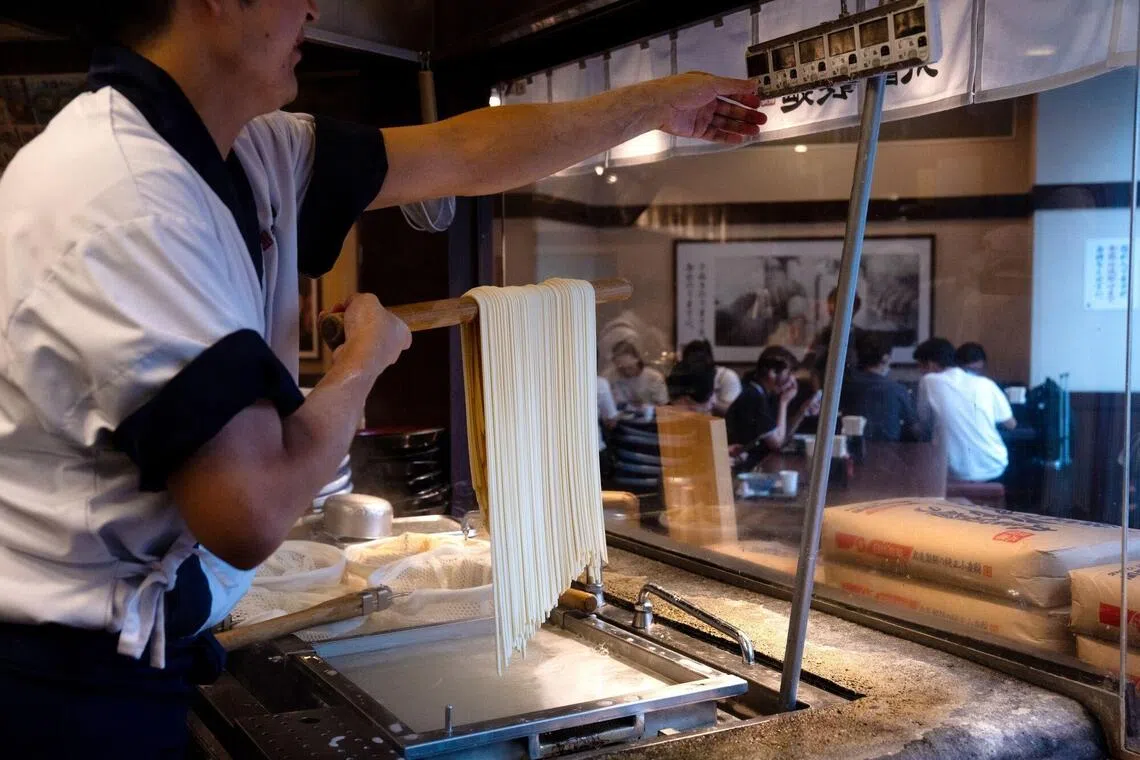 An employee prepares udon noodles at a Marugame Seimen restaurant in Tokyo.