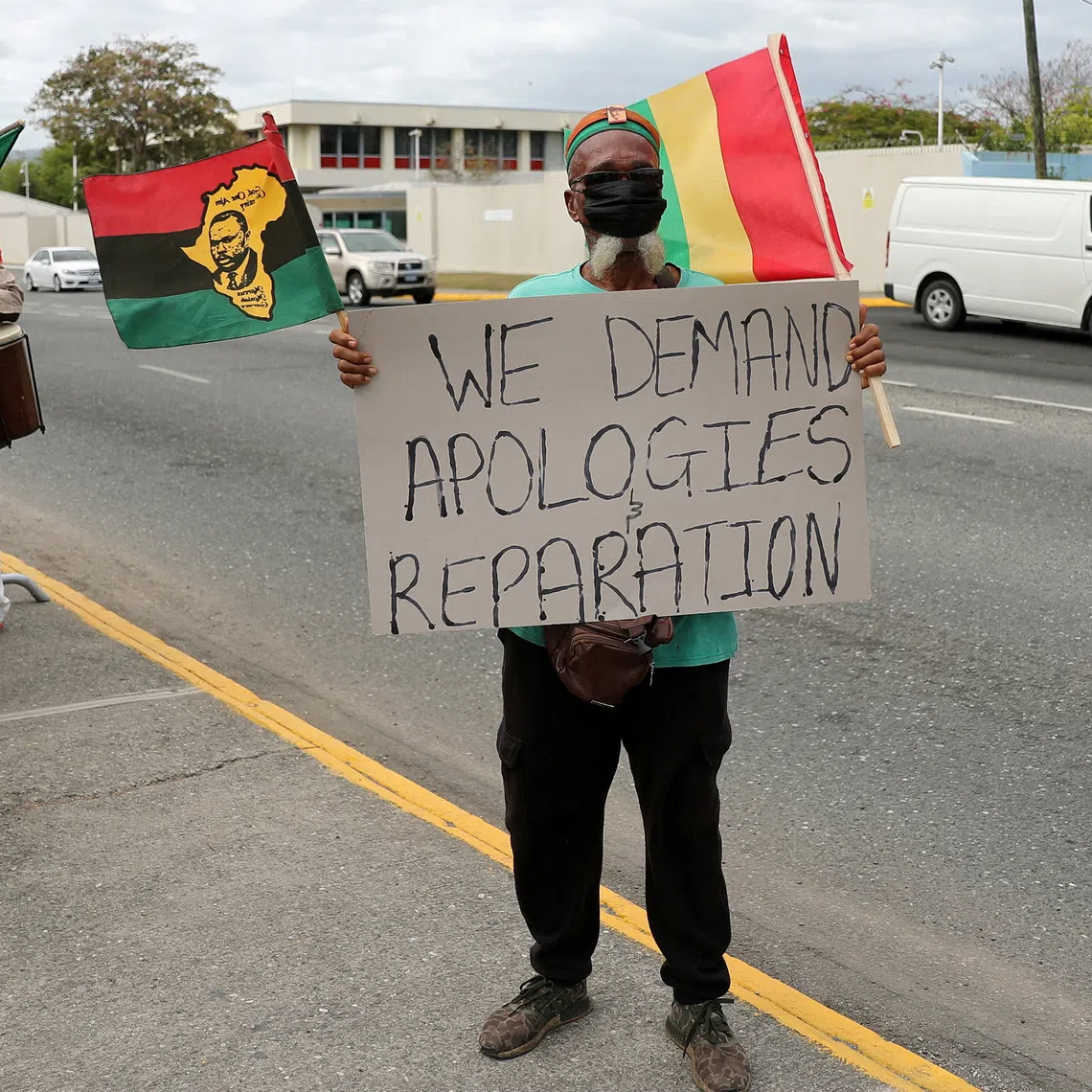 FILE PHOTO: A protester holds a sign during a rally to demand that the United Kingdom make reparations for slavery, outside the British High Commission, in Kingston, Jamaica March 22, 2022. REUTERS/Gilbert Bellamy/File Photo