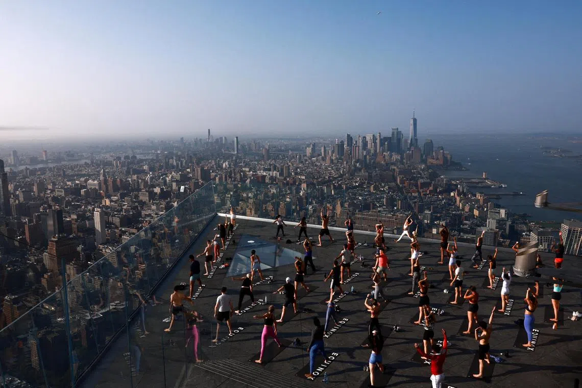 People taking part in a "Sky-High" yoga session on Manhattan’s Edge in New York City on July 26, 2023. 
