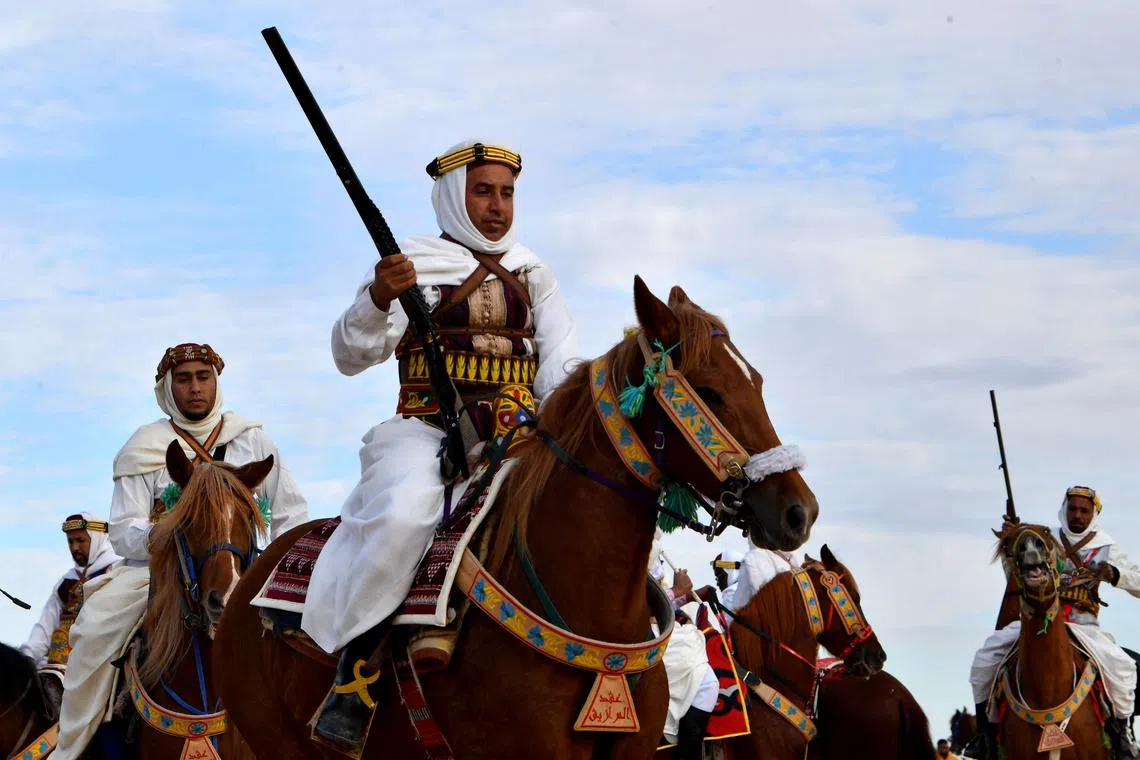 A performer wearing traditional outfit riding a horse at the start of the International Sahara Festival on Dec 27, 2023 in Douz, in southern Tunisia.