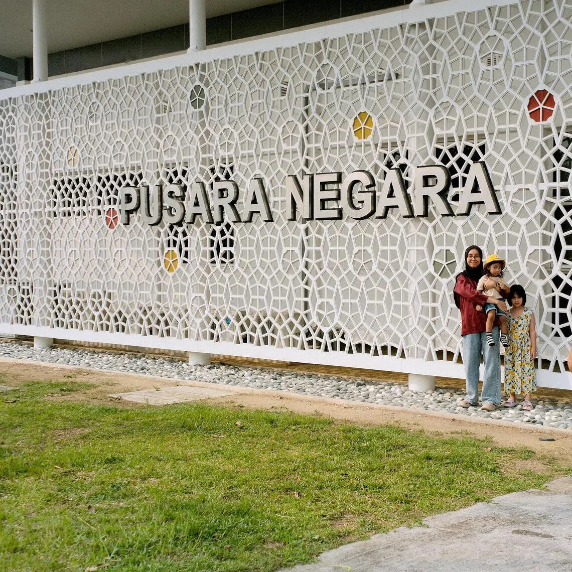 Visitors pose in front of the Pusara Negara (National Cemetery) sign after visiting the grave of Siti Hasmah Mohamad Ali.