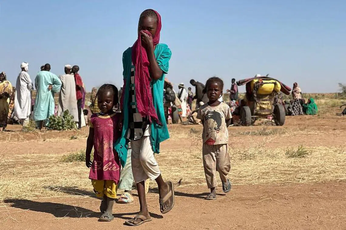 (FILES) A displaced Sudanese woman, accompanied by children, walks at a camp near the town of Tawila in North Darfur on February 11, 2025, amid the ongoing war between the army and paramilitary forces. Since April 2023, Sudan has been locked in a brutal conflict between the army and the paramilitary Rapid Support Forces (RSF). Fleeing a brutal paramilitary attack in April on Zamzam, once one of Sudan's largest displacement camps, an estimated 300,000 people have since arrived in the small farming town of Tawila in the country's war-battered Darfur region, according to the United Nations. (Photo by AFP)