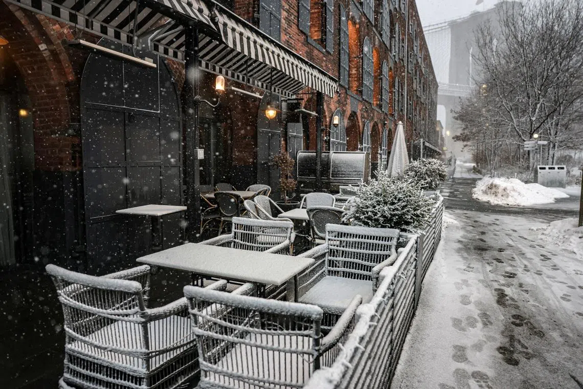Chairs are covered in snow in front of a restaurant as snow falls during a winter storm in the Brooklyn Borough of New York City on Feb 22.