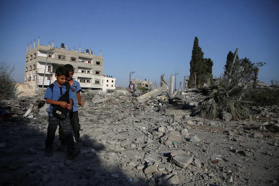 Palestinian boys walk on rubble, following an Israeli strike on a school sheltering displaced people, amid the Israel-Hamas conflict, in Khan Younis, in the southern Gaza Strip, June 27, 2024. REUTERS/Hatem Khaled