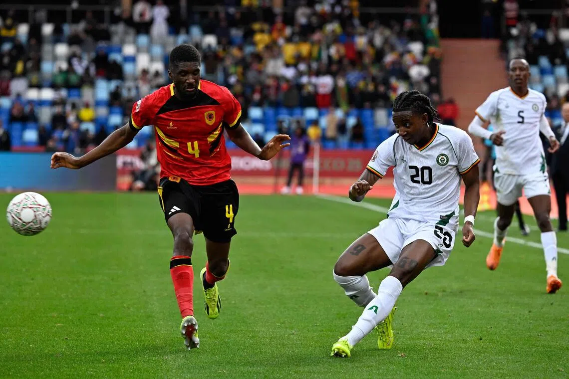 Zimbabwe forward Tawanda Chirewa crosses the ball past Angola defender Clinton Mata in the Africa Cup of Nations (CAN) Group B football match between at Marrakesh Stadium on Dec 26, 2025.