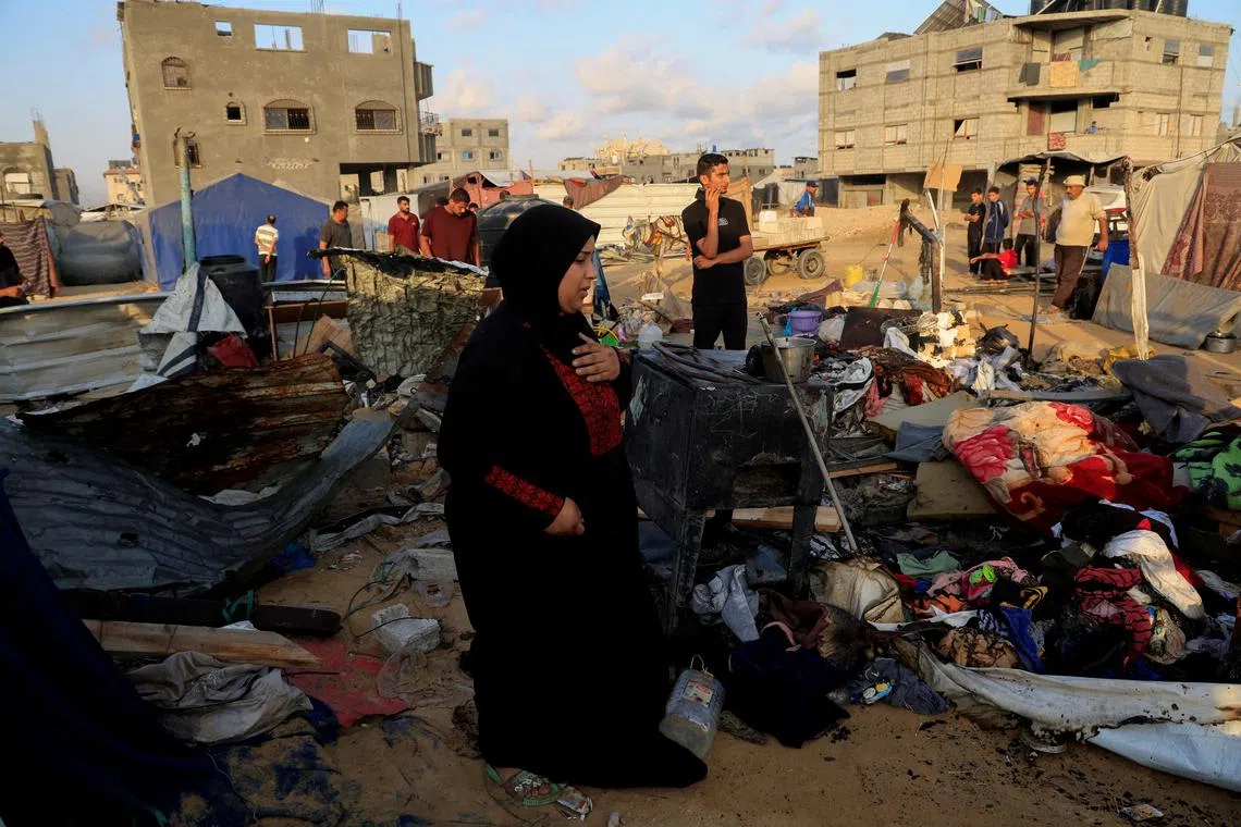 Palestinians inspect the damage at the site of an overnight Israeli air strike on a tent sheltering displaced people, in Khan Younis, southern Gaza Strip, July 2, 2025. REUTERS/Hatem Khaled     TPX IMAGES OF THE DAY