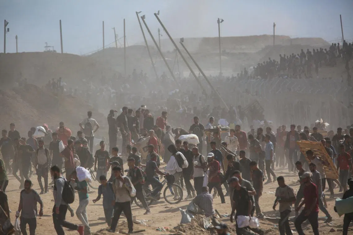 FILE PHOTO: Palestinians carry aid supplies which they received from the U.S.-backed Gaza Humanitarian Foundation, in the central Gaza Strip, July 31, 2025. REUTERS/Stringer/File Photo