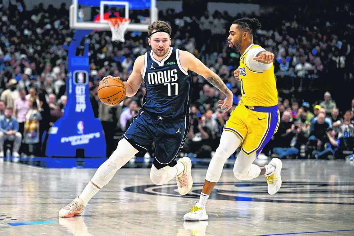Dallas Mavericks guard Luka Doncic drives to the basket past Los Angeles Lakers guard D'Angelo Russell.