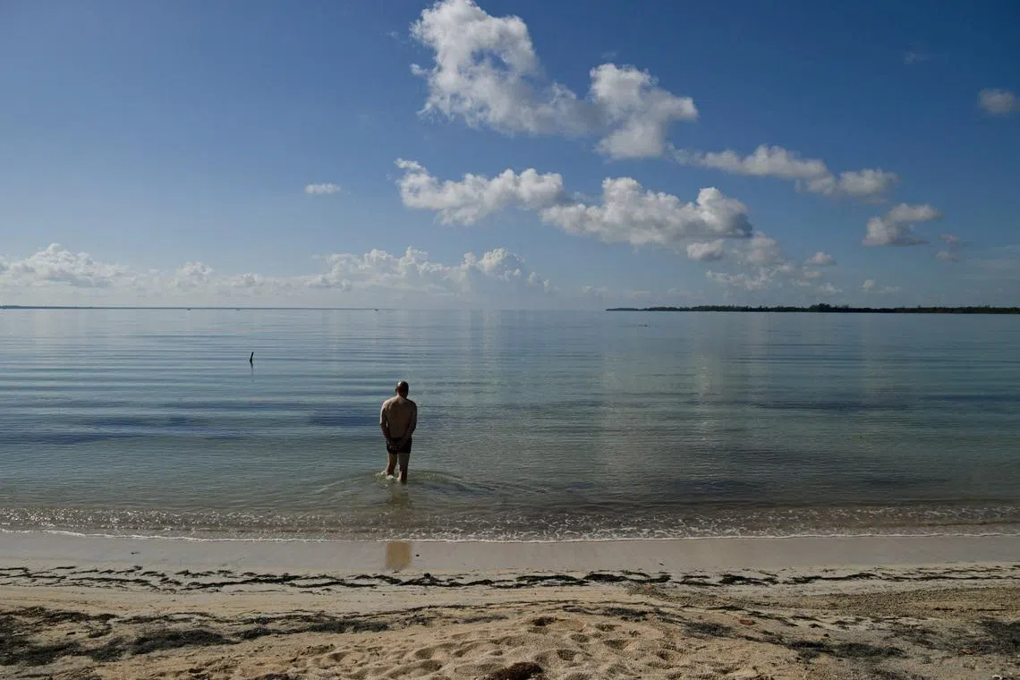 A German tourist walks into the water as Cuba's top tourist destinations remain deserted amid power and fuel shortages under U.S. sanctions, with international tourist arrivals plunging 56 per cent in February from a year earlier, in Playa Larga, Cienaga de Zapata, Cuba, April 8, 2026. REUTERS/Norlys Perez