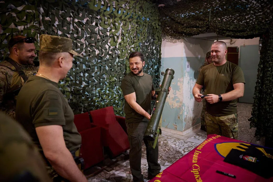 Ukraine's President Volodymyr Zelensky holds a shoulder-launched anti-tank missile as he visits servicemen in Ukraine's Donetsk region.