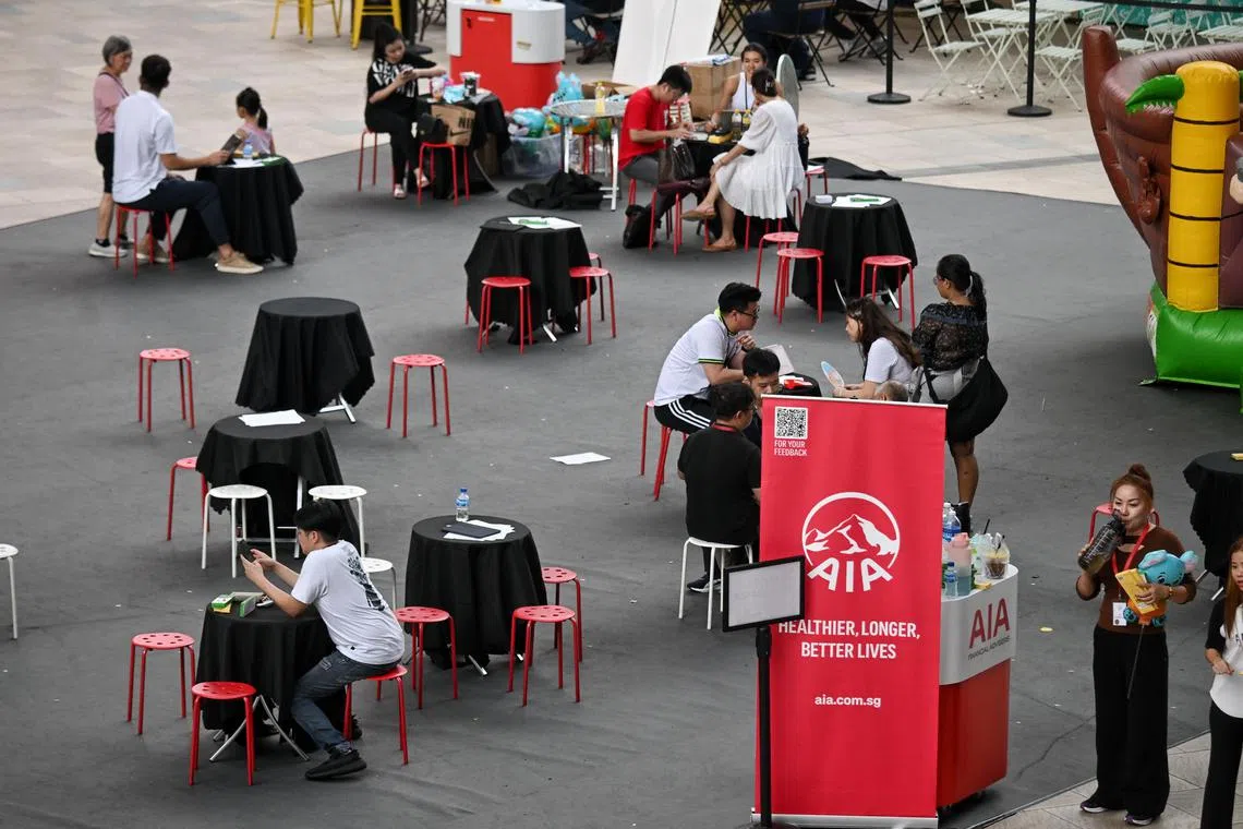 ST20240503_202421361534 Kua Chee Siong/ pixgeneric/ Generic pix of AIA insurance agents speaking to potential customers at a roadshow at the PLQ Plaza in Paya Lebar, on May 3, 2024.