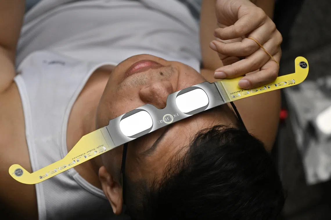 The founder of Singapore Sidewalk Astronomy using an eclipse viewer to see the solar eclipse at Toa Payoh Hub at 12.23pm on April 20, 2023. The rare astronomical event was supposed to be visible in Singapore, but was obscured by rain clouds.