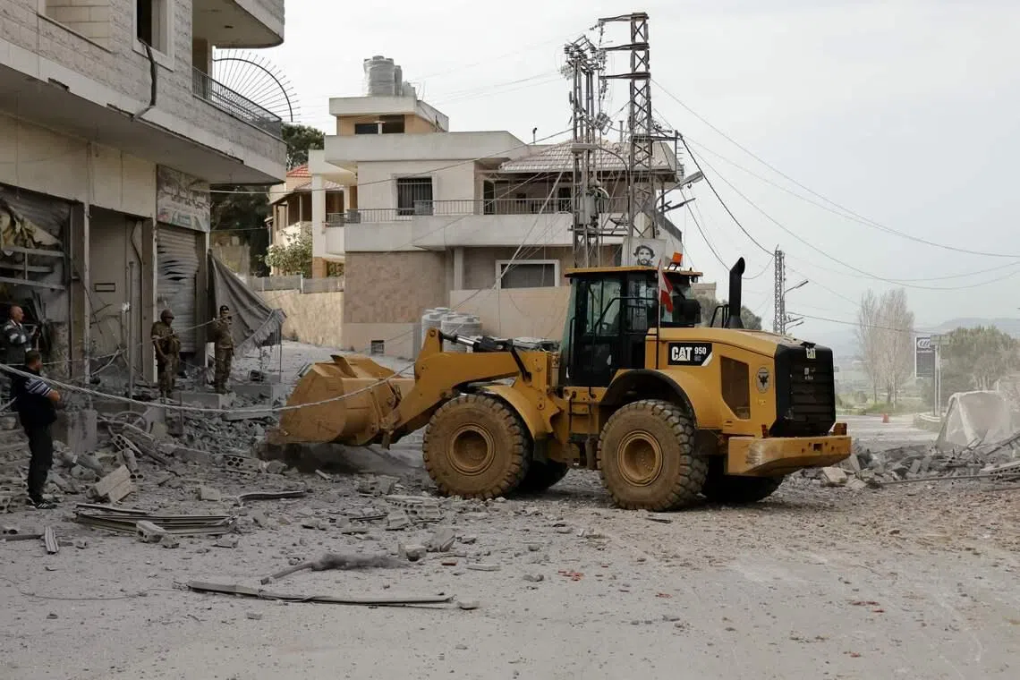 Lebanese army soldiers use a bulldozer to reopen a road that was previously targeted in Israeli strikes.