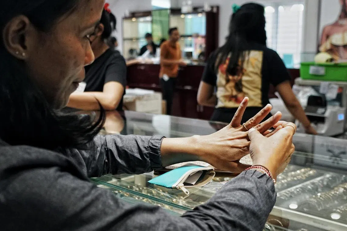 jdgold - Endang Kusumaningsih, 43, tries on rings for herself, including two she will give as birthday gifts to her daughter next month, in the gold market district in Denpasar, Bali this week. Indonesian consumers are buying gold as the economy recovers to replace jewelry and bars sold during the pandemic.

 Credit: Amilia Rosa
