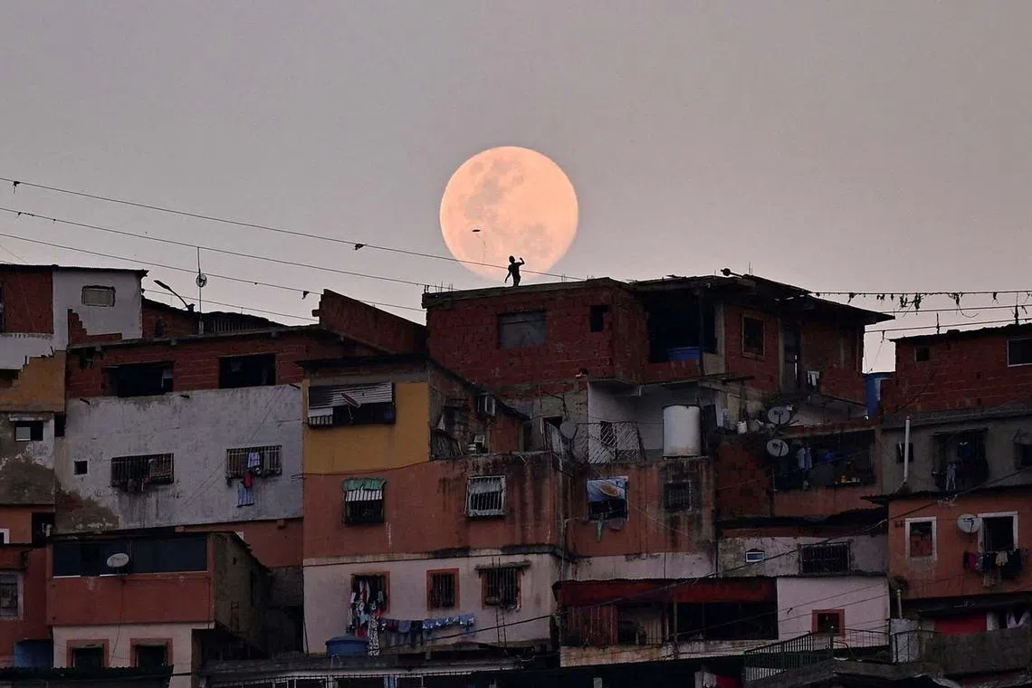 A child flying a kite during a moonrise in the neighbourhood of Petare, in Caracas, Venezuela, March 12, 2025. 