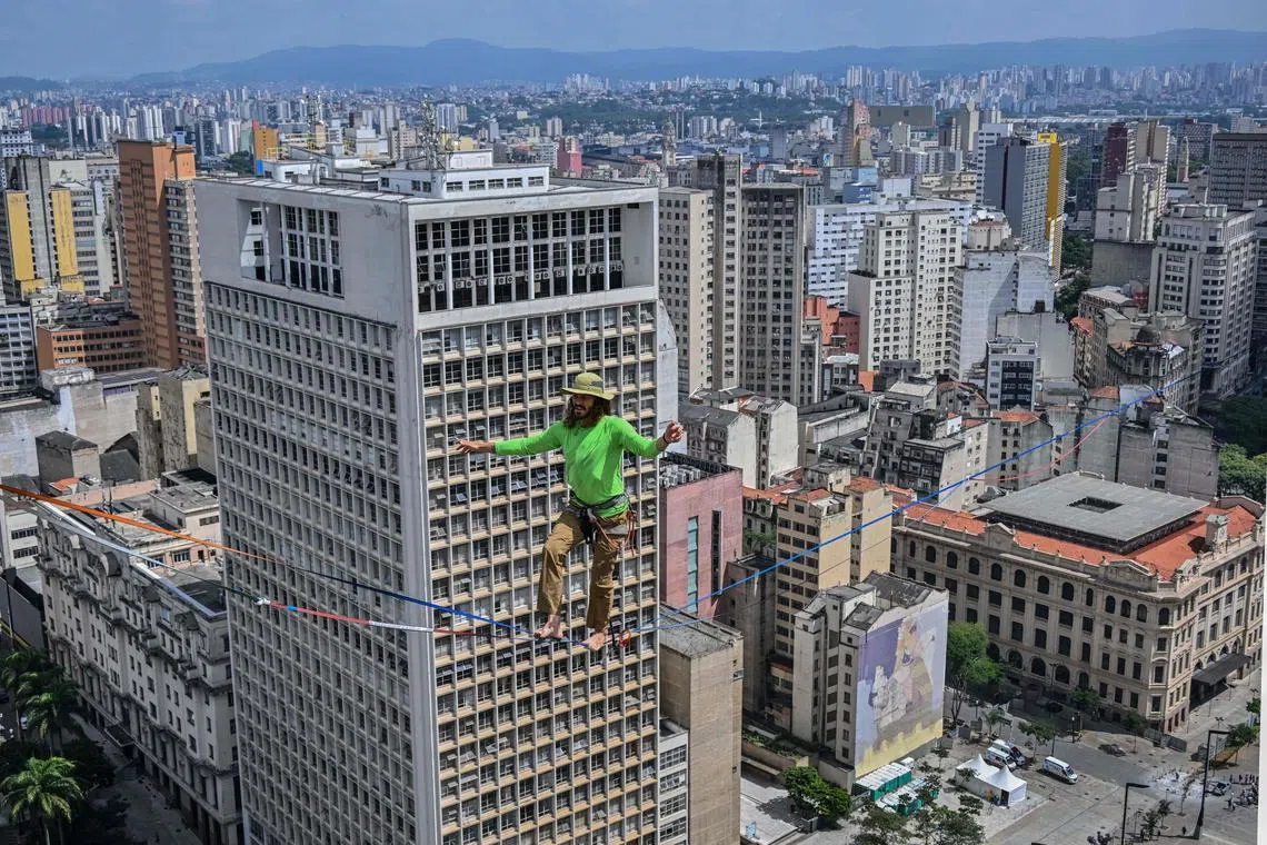Brazilian highliner Rafael Bridi performs on a slackline 114 metres high and 510 metres long, crossing the entire Vale do Anhangabau, as part of the 469th anniversary of the city of Sao Paulo, Brazil on Jan 25, 2023.  Bridi broke his own urban distance record for the Americas, according to the International Slackline Association.