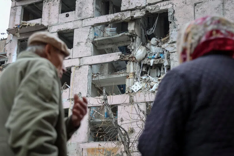 Residents standing near an apartment building hit during a military strike in the frontline town in Zaporizhzhia region, Ukraine.