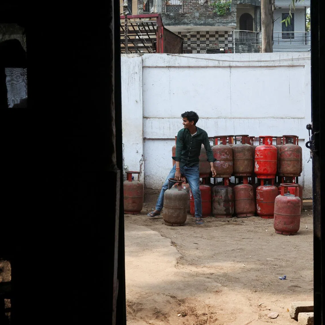FILE PHOTO: A worker moves an LPG cylinder at a godown, amid supply disruptions following the U.S.-Israeli conflict with Iran, in New Delhi, India, March 10, 2026. REUTERS/Bhawika Chhabra/File Photo