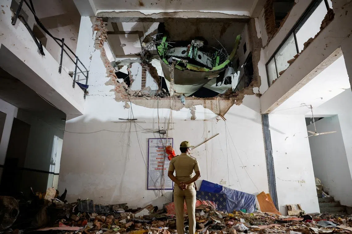 FILE PHOTO: A police officer stands in front of the wreckage of an Air India aircraft, bound for London's Gatwick Airport, which crashed and landed on a hostel building minutes after take-off from an airport in Ahmedabad, India June 12, 2025. REUTERS/Adnan Abidi/File Photo