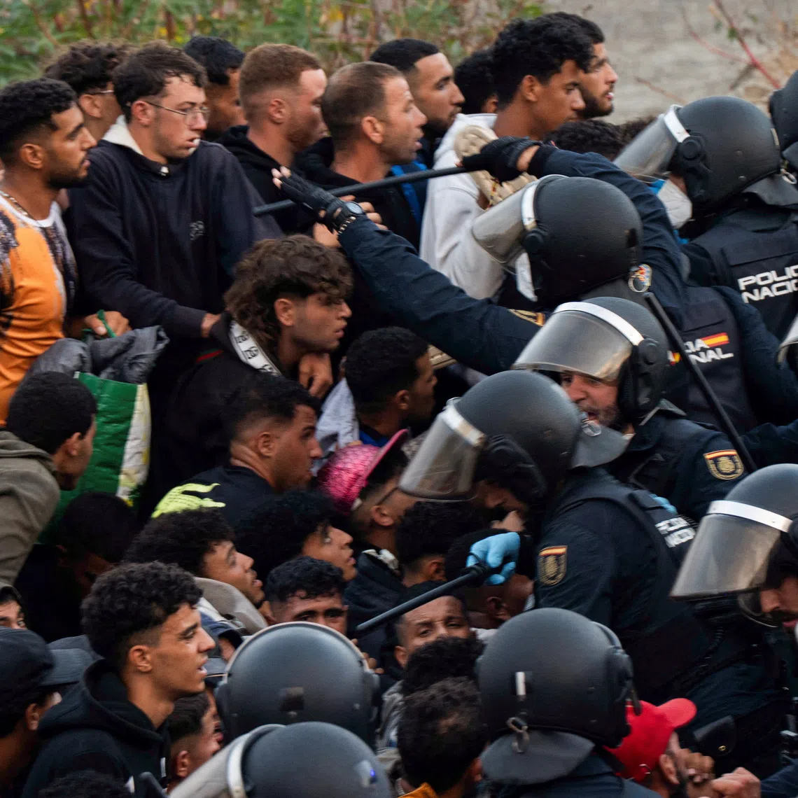 Police escort migrants from Benitez Beach to be relocated to the camp set up at the port of Ceuta, Spain, September 18, 2026. REUTERS/ Anna Surinyach