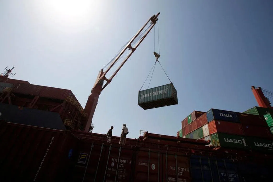 FILE PHOTO: Workers look on as a ship uses its crane to unload containers at a container terminal at the Red Sea port of Hodeidah, Yemen November 16, 2016. Picture taken November 16, 2016.  REUTERS/Khaled Abdullah/File Photo