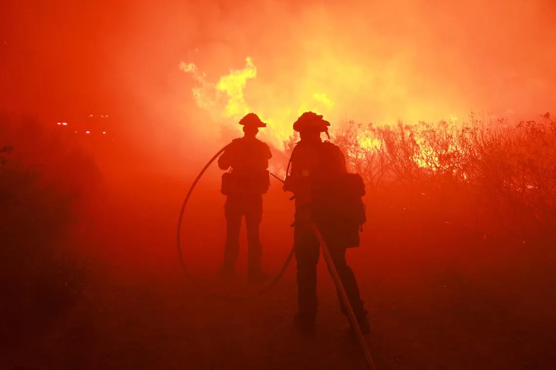 TOPSHOT - Firefighters from the Los Angeles Fire Department (LAFD) and other firemen respond to the Post Fire as it burns through the Hungry Valley State Vehicular Recreation Area in Lebec, California, on June 16, 2024. The fire has grown to 4,400 acres, with evacuation orders in place for Gorman, Pyramid Lake and Hungry Valley State Vehicular Recreation Area, according to the US Department of Agriculture Forest Service at Los Padres National Forest. (Photo by DAVID SWANSON / AFP)
