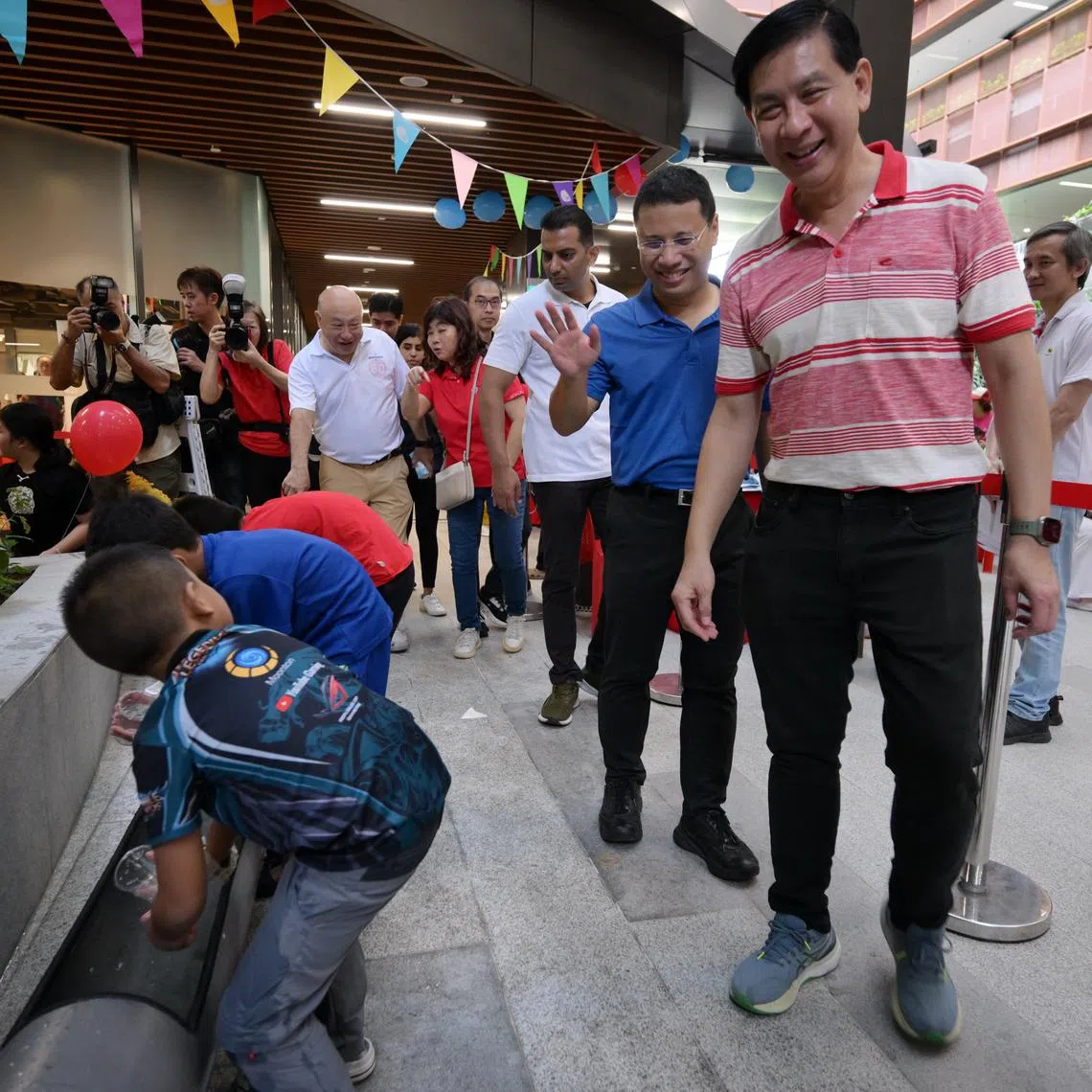 Three-term MP Ang Wei Neng (right) with National Development Minister Desmond Lee (second from right) at a carnival at CleanTech Three on Feb 15.