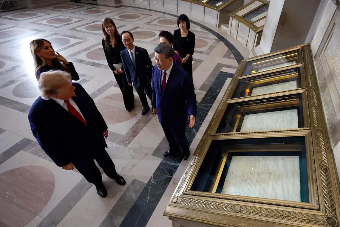 US President Donald Trump and Chinese President Xi Jinping viewing the US Constitution during a tour of the National Archives alongside First Lady Melania and First Lady Peng Liyuan.