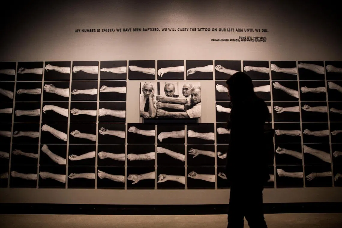 A visitor views photos of tattoos from Auschwitz at the United States Holocaust Memorial Museum in Washington, DC.