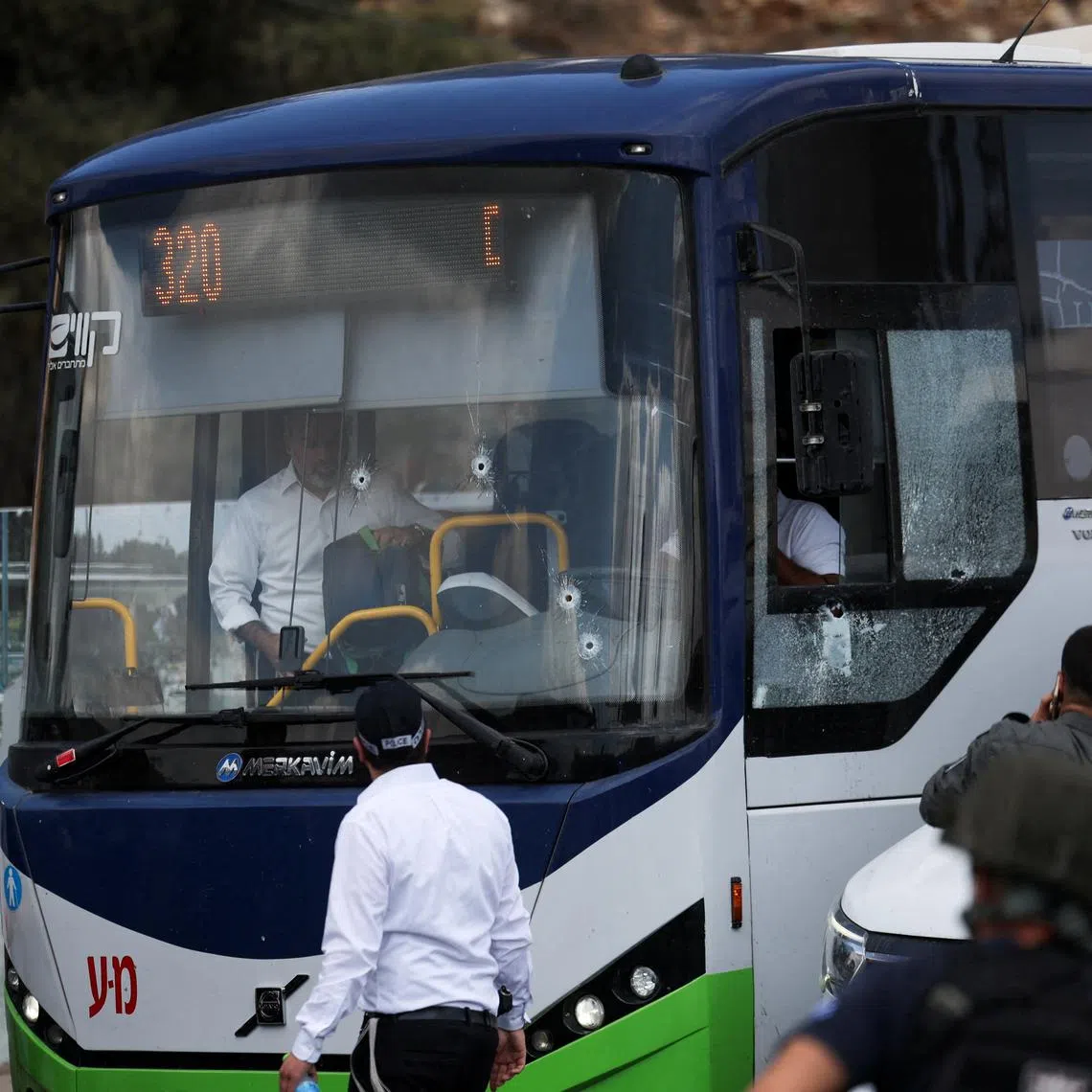 People inspect a bus with bullet holes in the windshield at the scene where a suspected shooting attack took place at the outskirts of Jerusalem, September 8, 2025 REUTERS/Ronen Zvulun     TPX IMAGES OF THE DAY